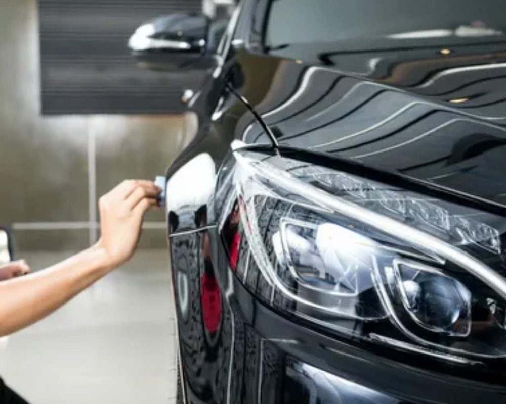 Protective coating being worked over a car's front end