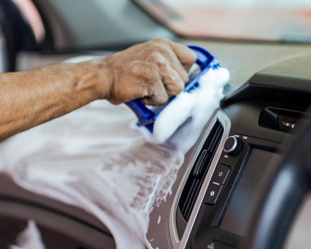 Interior surfaces being foam cleaned inside a car